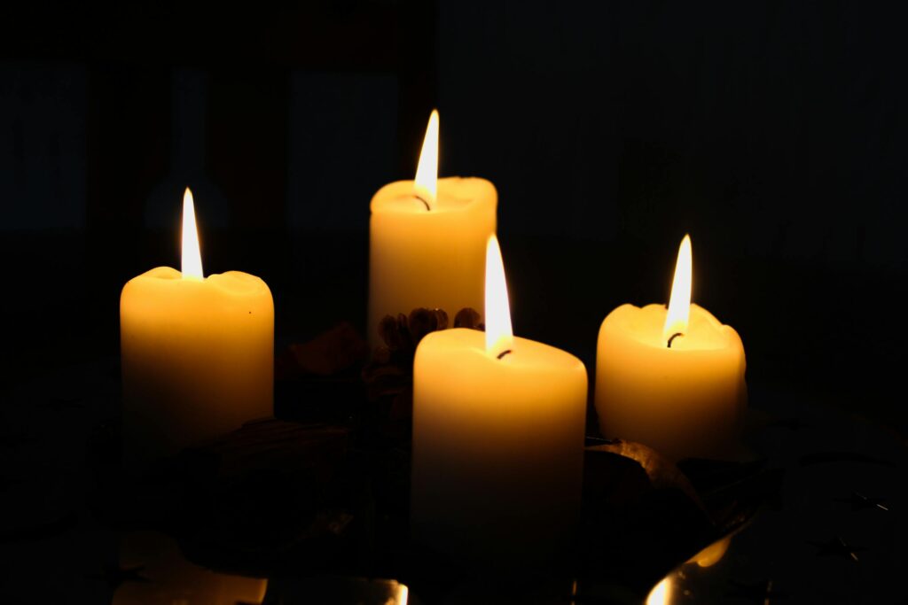 A serene image of a glowing four-candle advent wreath, perfect for holiday ambiance.