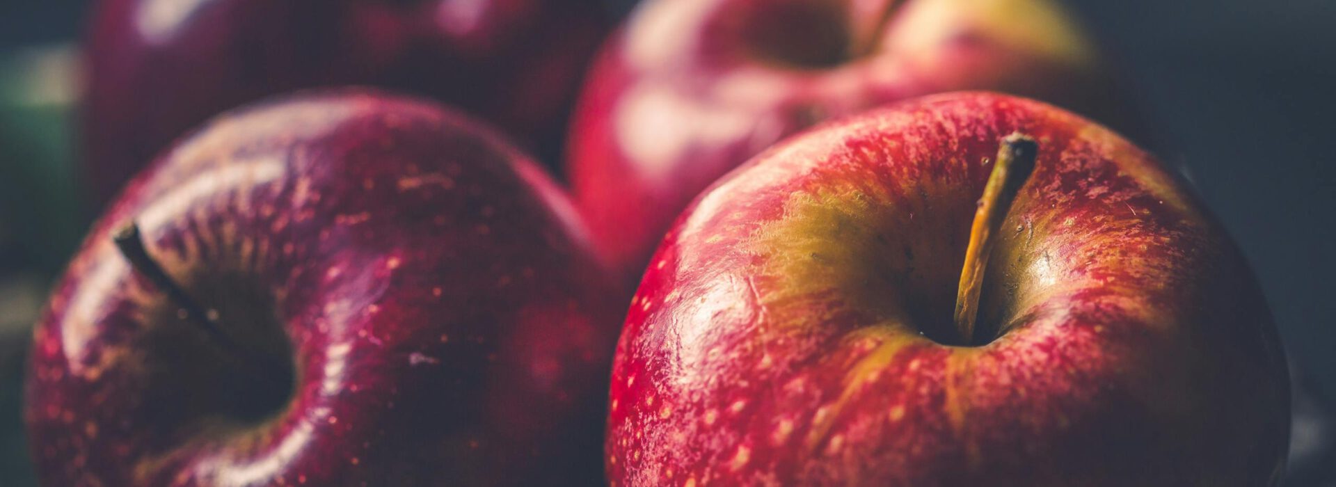 Vibrant red apples glistening with freshness in a close-up view.
